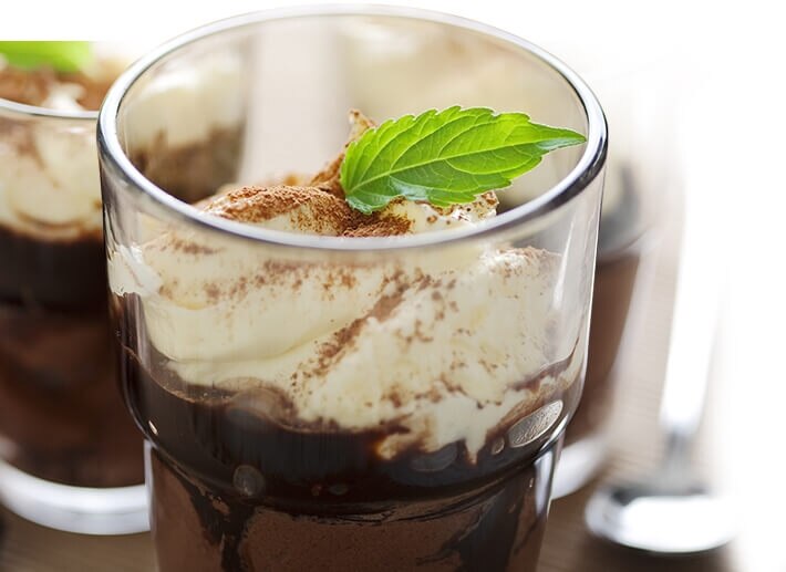 Mousse Caramel mit Sahne und Minzblatt
